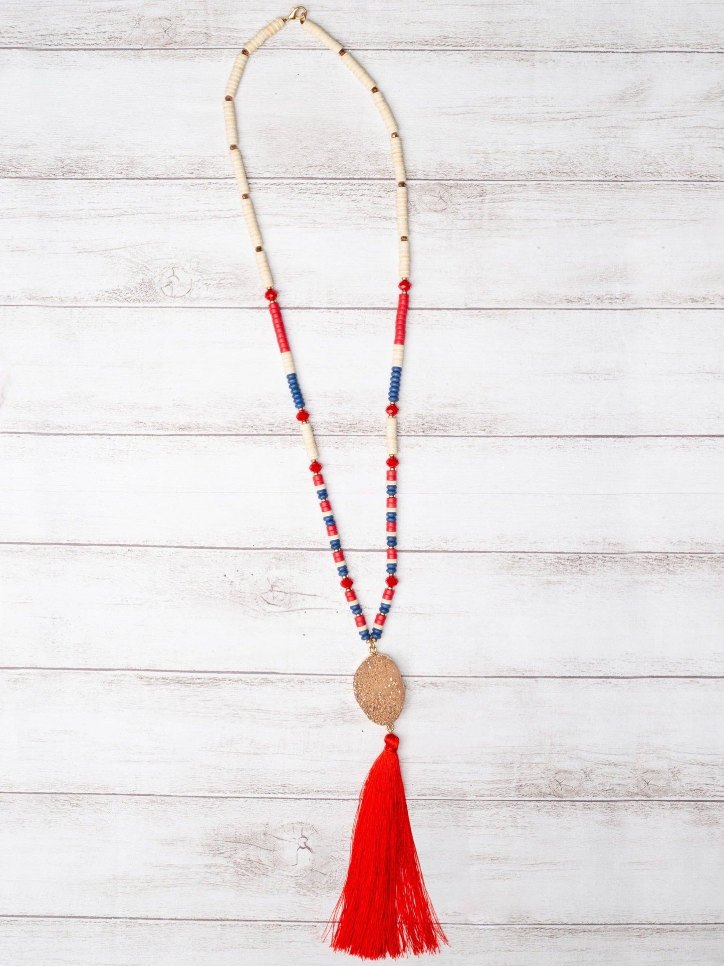 GOOD TIMES AND TAN LINES ROSE GOLD DRUZY STONE PENDANT WITH RED TASSEL ON A MIXED FLAT BEADED NECKLACE: Patriotic / One Size